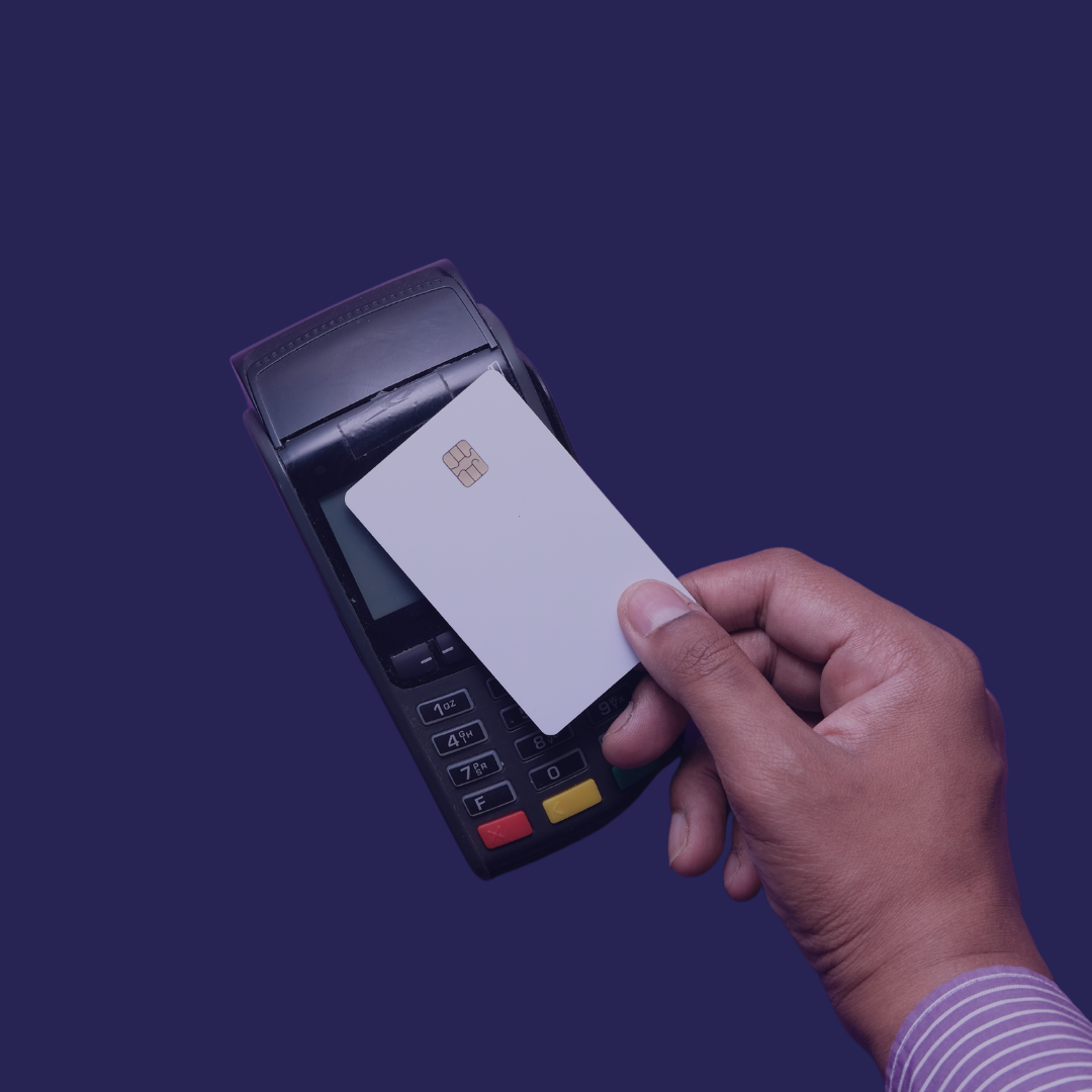 A close up hand makes a purchase with a credit card