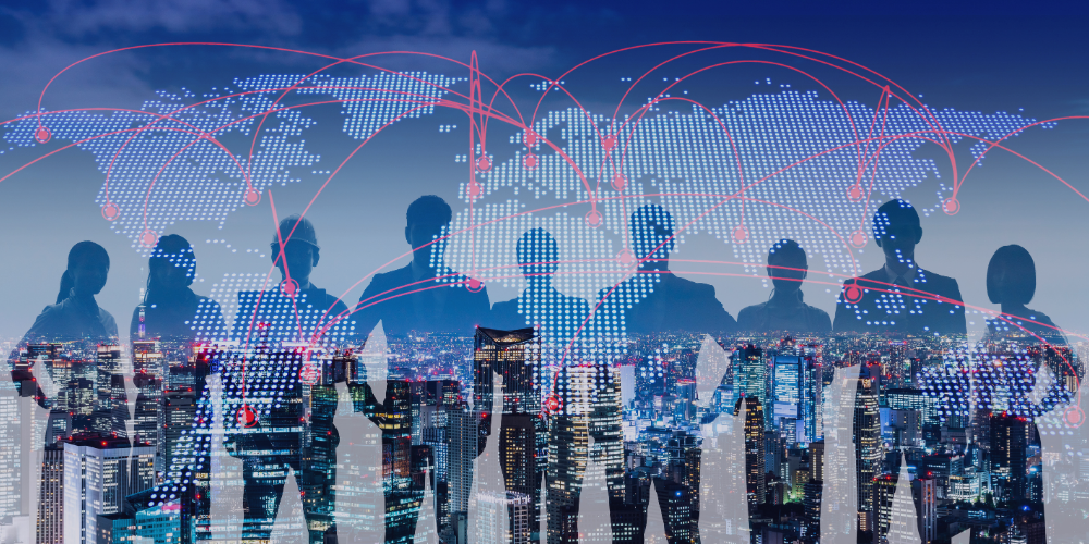 Silhouettes of professionals stand in front of a night skyline
